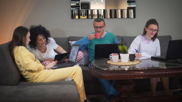 A family working and studying together on the couch